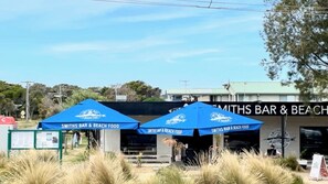 A beachside restaurant named 'SMITHS BAR & BEACH FOOD' with outdoor seating and blue umbrellas. - Number Thirty One Smiths Beach Phillip Island (Smiths Beach)
