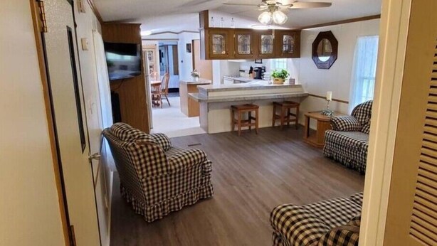 Un espacio habitable compacto con kitchenette, comedor y dos sillones a cuadros.