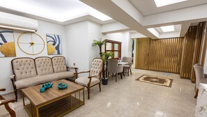 A spacious living room with a sofa, armchairs, a coffee table, and a dining area. - LINNGA HOTEL & SUITE (Istanbul)