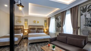 A hotel room with two beds, a sofa, a wooden coffee table, and wall-mounted lamps. - LINNGA HOTEL & SUITE (Istanbul)