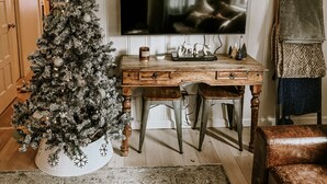 A living room with a wooden desk, a television, a Christmas tree, and a fireplace. - Pet friendly 2bed 2bath sleeps 6 Cabin in Kings Beach (Kings Beach)