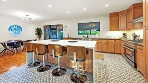 Uma cozinha moderna com ilha central, armários de madeira e piso estampado.