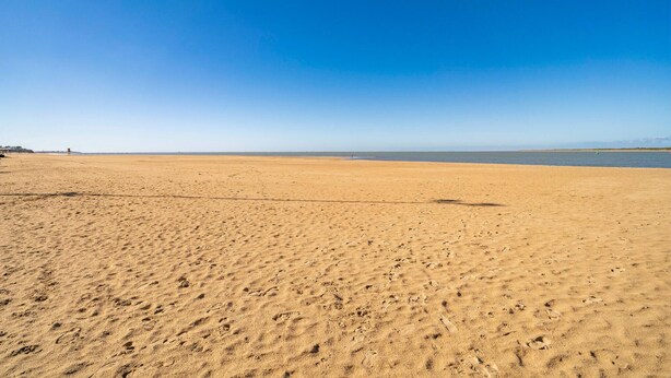 A wide sandy beach with footprints and a clear blue sky. - Cozy apartment in Sanlúcar de Barrameda (Sanlúcar de Barrameda)