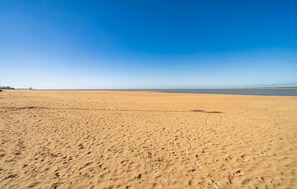 A wide sandy beach with footprints and a clear blue sky. - Cozy apartment in Sanlúcar de Barrameda (Sanlúcar de Barrameda)