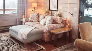 A cozy bedroom with a bed, a nightstand, a chair, and a window. - Cozy Cabin with Private Hot Tub and Stunning Views (Silverthorne)
