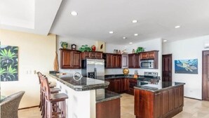 Una cucina moderna con mobili in legno, un'isola centrale ed elettrodomestici integrati.