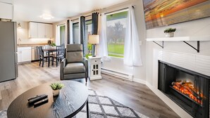 Un salon moderne doté d’une cheminée, d’un coin repas et d’une cuisine.