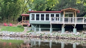Un chalet au bord du lac, doté d’un quai, d’une terrasse couverte et d’un petit espace de détente extérieur.