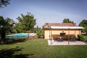 Il s’agit d’une propriété résidentielle dotée d’une piscine, d’un espace extérieur aménagé et d’un toit recouvert de tuiles.