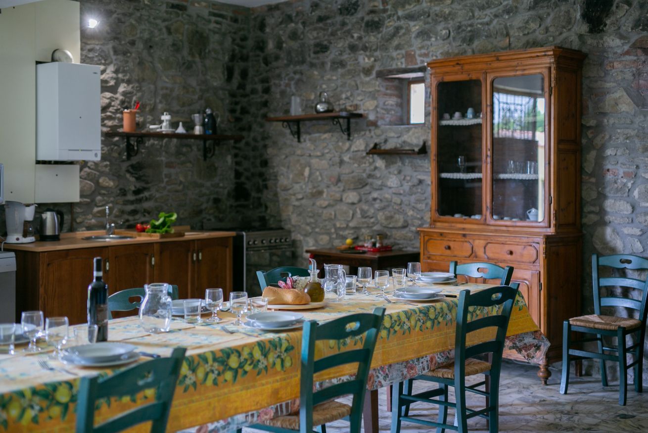 A dining area with a stone wall, wooden cabinets, and a table set for four.