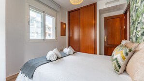 Une chambre d’hôtel avec un grand lit, une armoire en bois et une fenêtre équipée de stores.