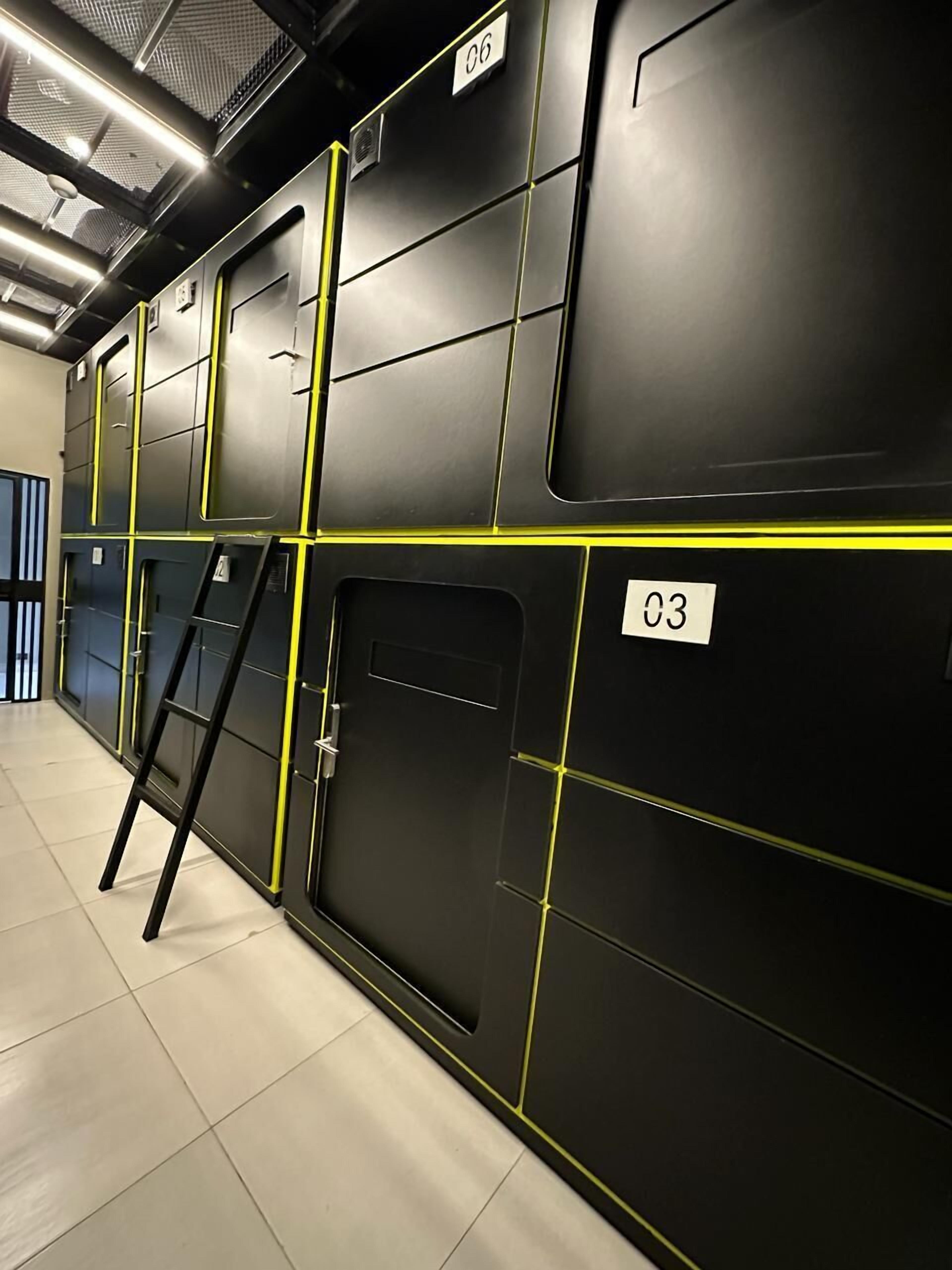 A modern, industrial-style storage area with black lockers and yellow accents, labeled with numbers 03 and 06.