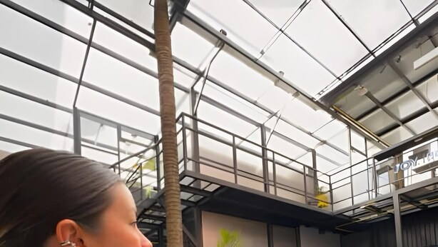A person dining at an indoor restaurant with a modern industrial design, featuring exposed ceilings and metal structures. - Hostal Joy Calle 85 (Bogotá)
