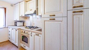 A kitchen with white cabinets, a microwave, a stove, and a window. - GuestHost - Beautiful studio of 25 square meters located on the first floor of a building without elevator (6 steps to access), can comfortably accommodate up to 2 people.The property is located in the historic center (Restricted Traffic Zone), just outs (Siensa)