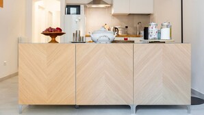 A modern kitchen with a herringbone-patterned wooden cabinet, a white bowl, and a fruit bowl on the counter. - Casa San Martino in the feel of the middle age (Firenze)