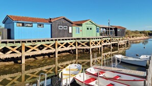A wooden pier with colorful wooden buildings and boats docked at the end.