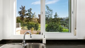 Une cuisine avec une fenêtre, un évier et un plan de travail.