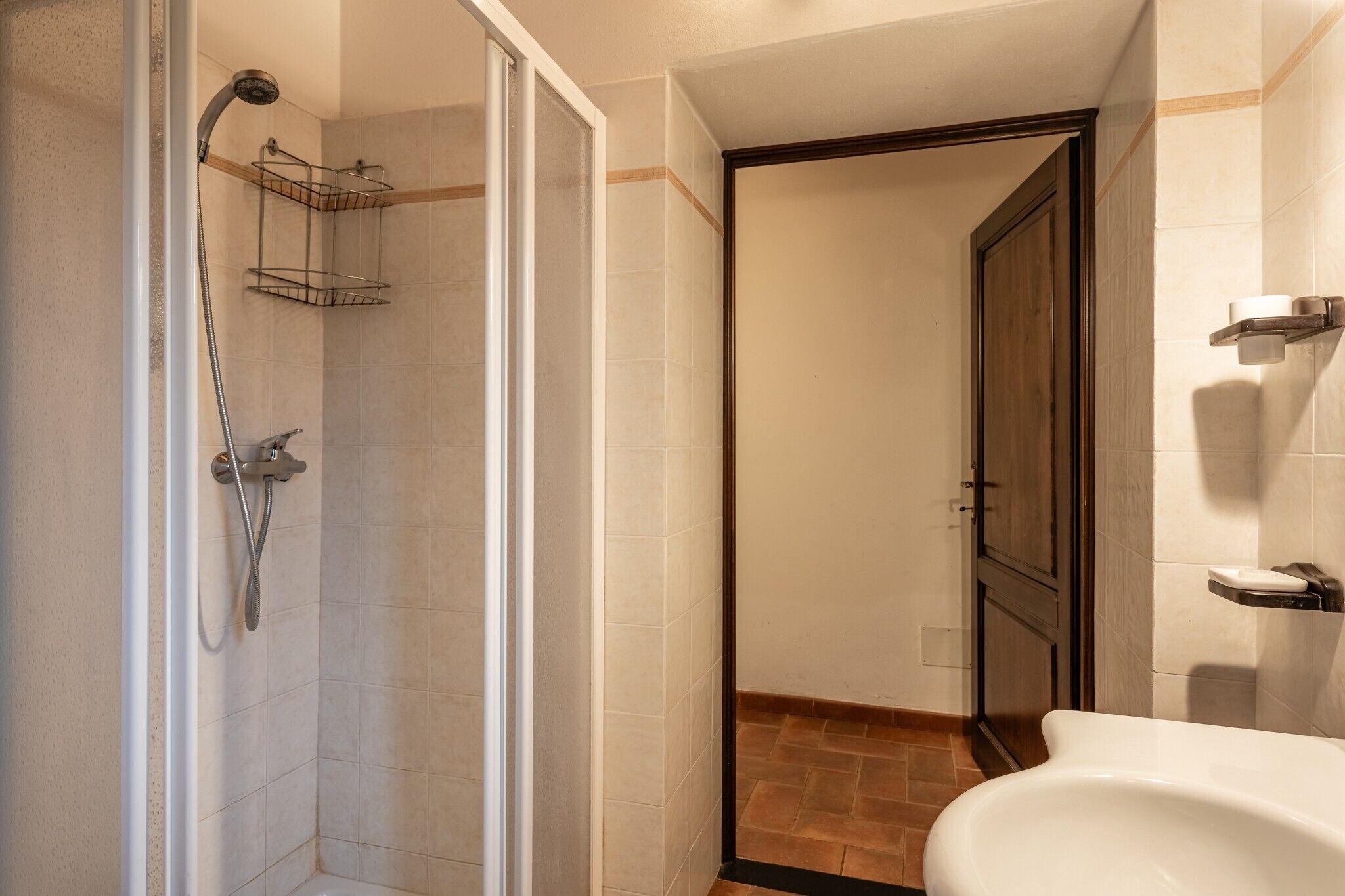 Une salle de bain avec douche, toilettes et lavabo.