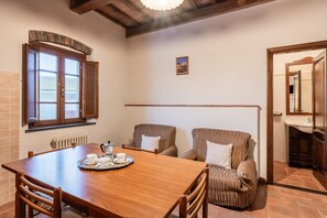 A dining area with a wooden table, chairs, and a radiator.