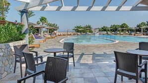 A pool area with lounge chairs, a pool, and a pergola structure.