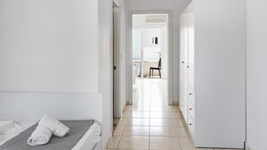 Habitación de hotel con cama, armario y vistas al balcón.