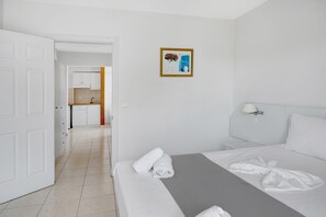 Une chambre d’hôtel comprenant un lit, une salle de bain, une cuisine et un couloir.