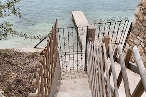 Una escalera que conduce a un muelle con un muro de piedra y una barandilla de metal.
