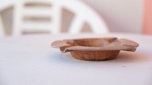 Un bol en bois sur une surface blanche.