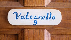 A wooden panel with a sign that reads 'Vulcanello 9'.