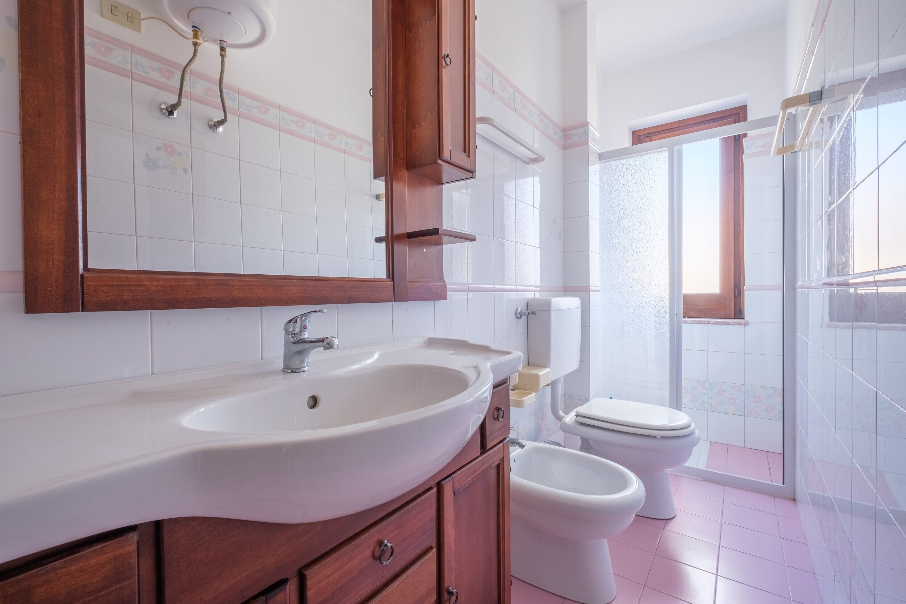 Une salle de bain avec un grand lavabo, des toilettes et un espace douche.
