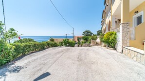 A coastal road with buildings on one side and the sea on the other. - Studio Apartment "Mazis Studio B2" with Sea View, Balcony & Wi-Fi (Corfu)