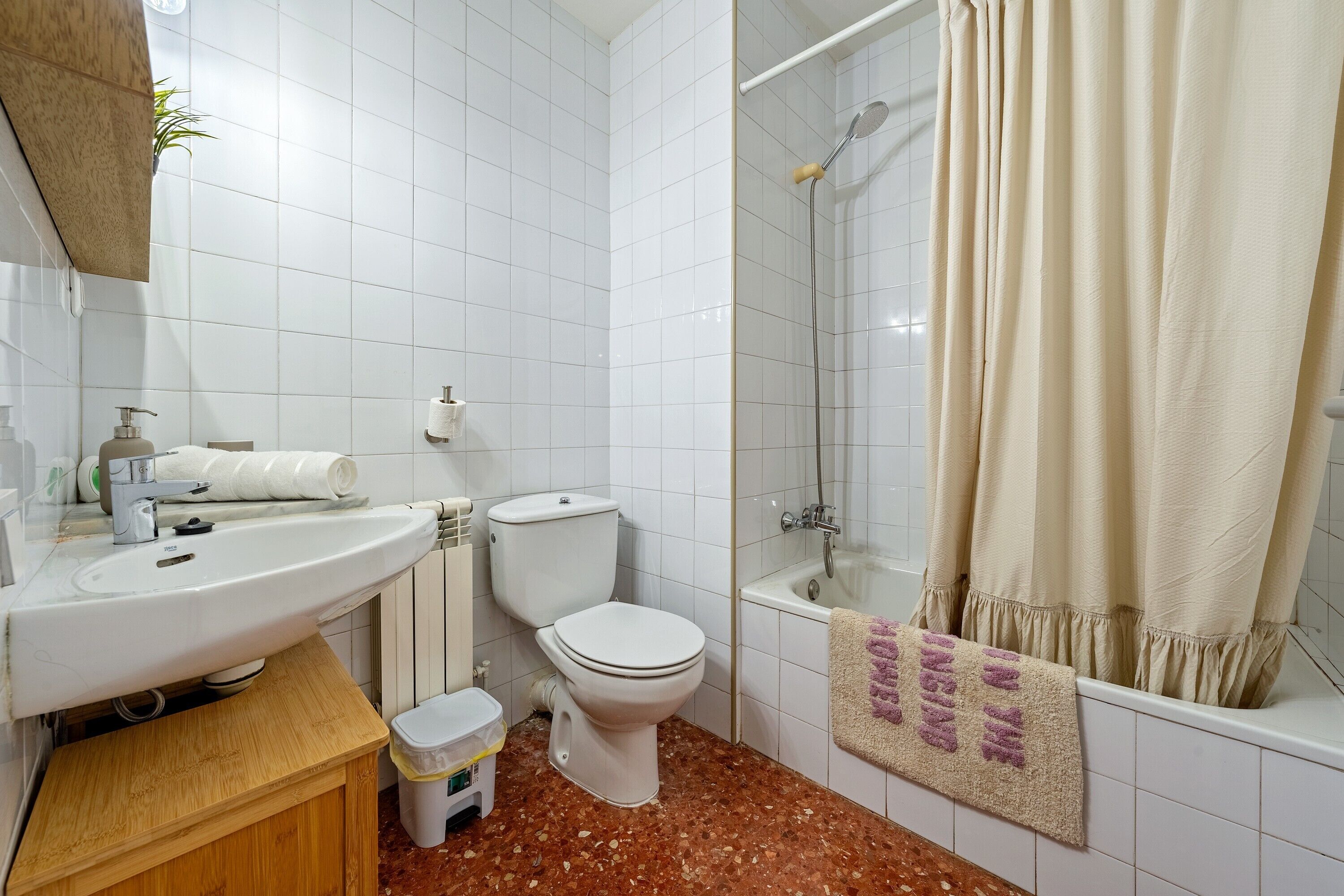 A bathroom with a sink, toilet, shower, and a towel with a message.