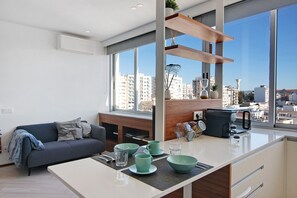 A modern kitchen with a large window, a sofa, and a coffee maker. - Studio Apartment "Casa Alameda" with Sea View & Wi-Fi (Faro)
