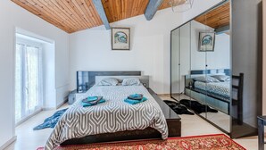 Un dormitorio con una cama, un espejo grande y vistas al exterior.