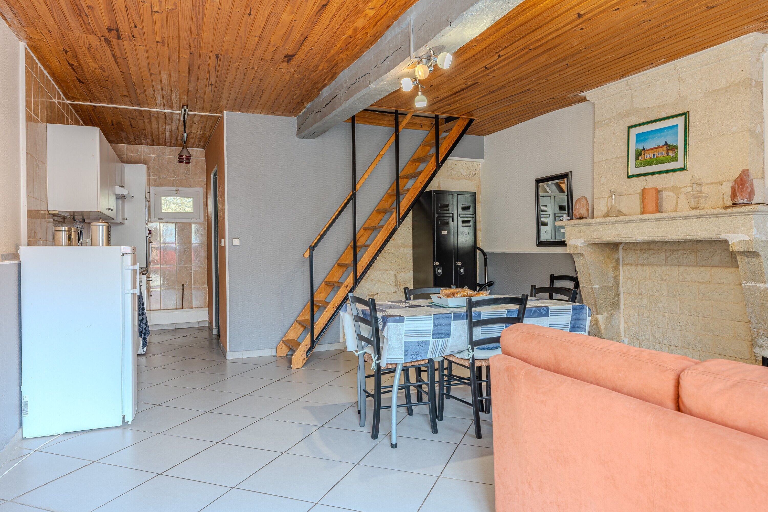 A spacious living area with a wooden ceiling, a dining table, and a sofa.