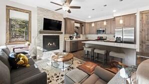 A modern kitchen with a fireplace, bar area, and a dining table. - Seasons at Keystone #1886 By Summit County Mountain Retreats (Keystone)