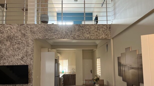 A spacious living area with a high ceiling, a kitchen, and a dining area. - 🌴 Your Dream Getaway in the heart of Accra! Stay in this 3 Bedroom Property! 🏡 (Accra)
