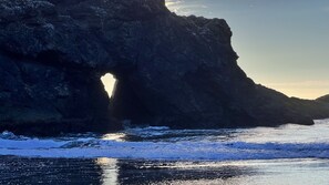 A coastal rock formation with a natural arch. - Secluded getaway 5 minutes from salmon fishing, kayaking, and whale watching! (Curry County)