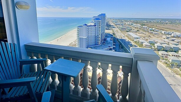 A balcony with a view of a beach and a high-rise building. - Top of The World * Penthouse Views * Free Daily Activities! (Gulf Shores)