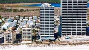 A coastal hotel with multiple buildings, a beach, and a body of water. - Top of The World * Penthouse Views * Free Daily Activities! (Gulf Shores)