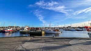 A marina with various boats docked, a clear sky, and a concrete walkway in the foreground. - 3 bedroom gorgeous home in Gilleleje (Gilleleje)