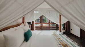 A bedroom with a large bed, sheer curtains, and a view of the outdoors. - Legian 6BR Villa 16px Big Group Walk to 66 Beach (Bali)