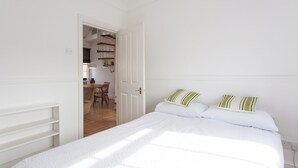 Un dormitorio con una cama, un escritorio y una silla.