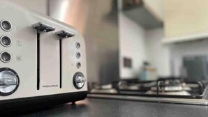 Une cuisine avec un grille-pain blanc posé sur un plan de travail.