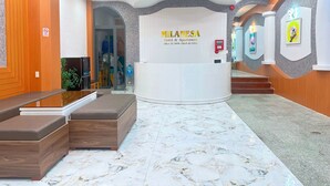 A reception area with a reception desk, seating area, and a staircase leading to upper floors. - Milanesa Hotel & Apartment (Ho Chi Minh City)