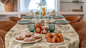 Et morgenbord dækket med tallerkener, glas og kager.