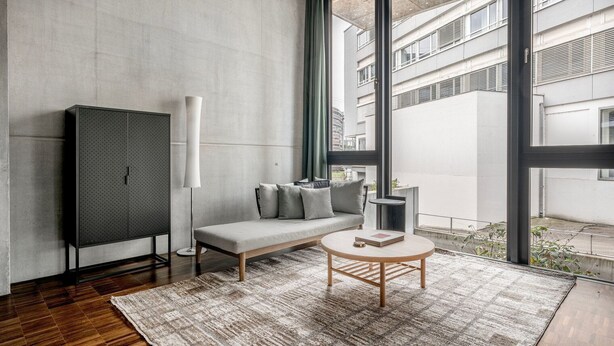 A modern room with a sofa, a round coffee table, a tall floor lamp, and a wardrobe. - Clean Wiedikon 2BR w/ Storage & W/D, close to Market, by Blueground (Zurich)