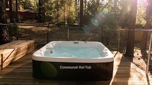 A communal hot tub on a wooden deck surrounded by trees. - Sleep Inn - Ultra Clean Ultra Modern / C2 (Big Bear Lake)