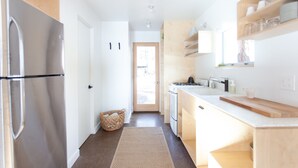 Une cuisine moderne équipée d’un réfrigérateur, d’une cuisinière et de meubles de rangement en bois.