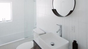 Ein modernes Badezimmer mit Waschbecken, Spiegel und Toilette.